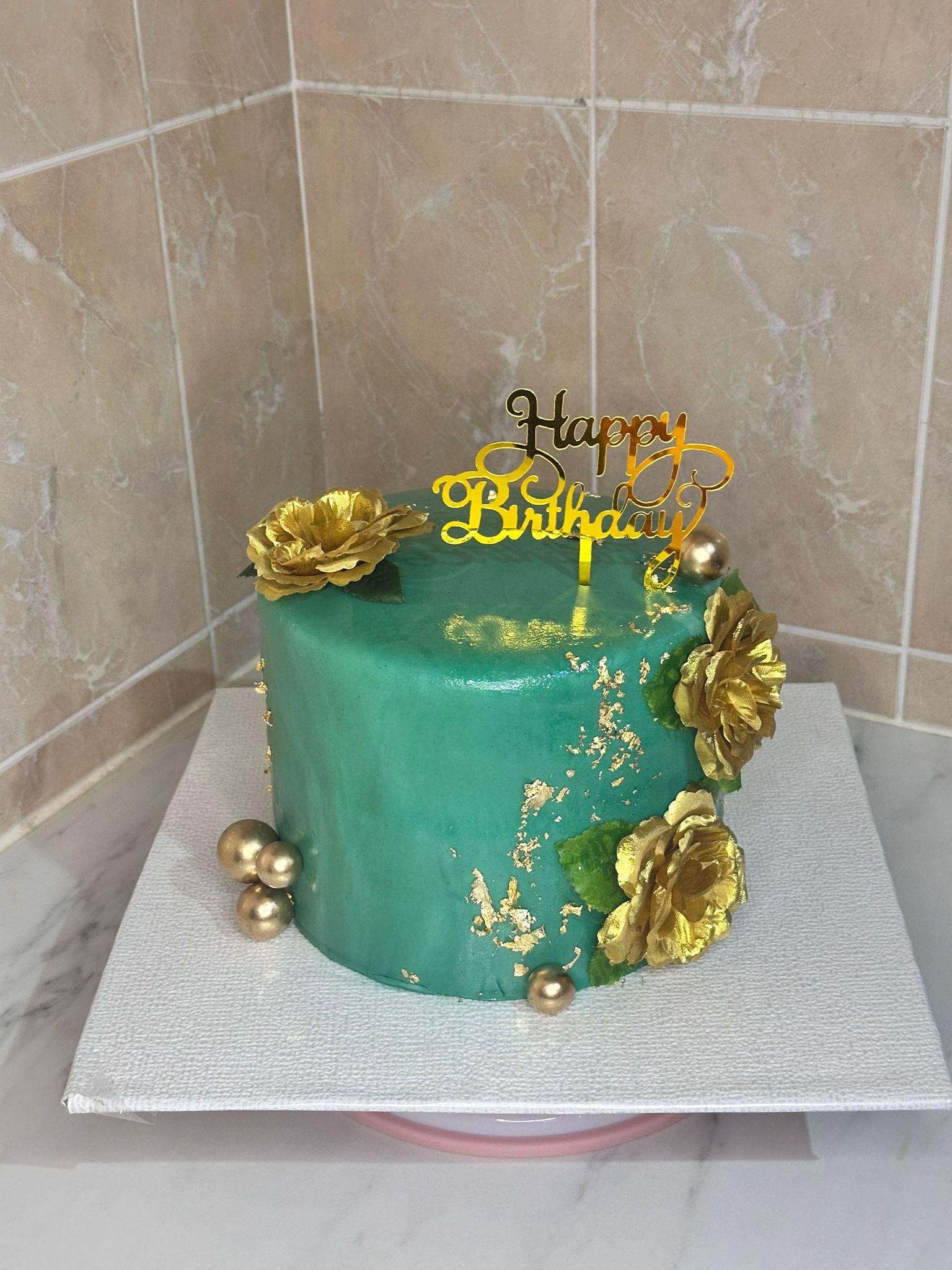 Gâteau émeraude et or avec fleurs dorées