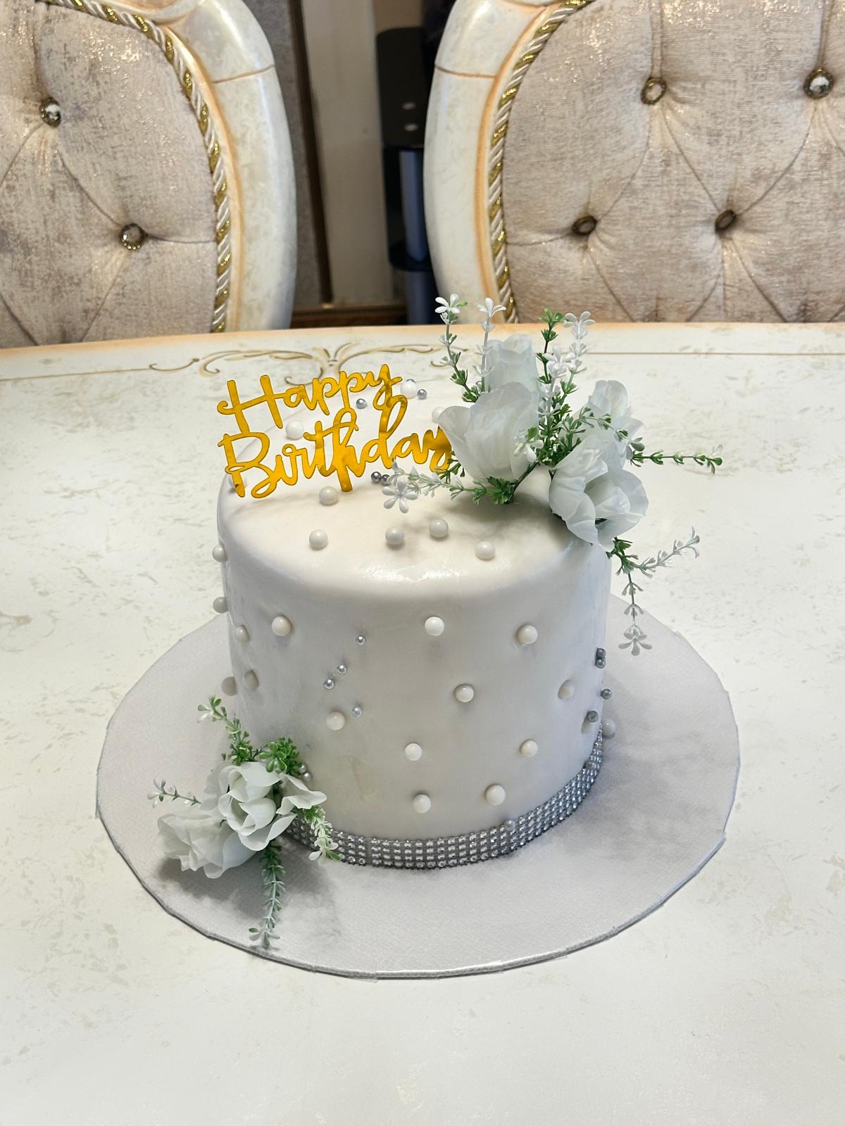Gâteau blanc élégant avec perles et fleurs